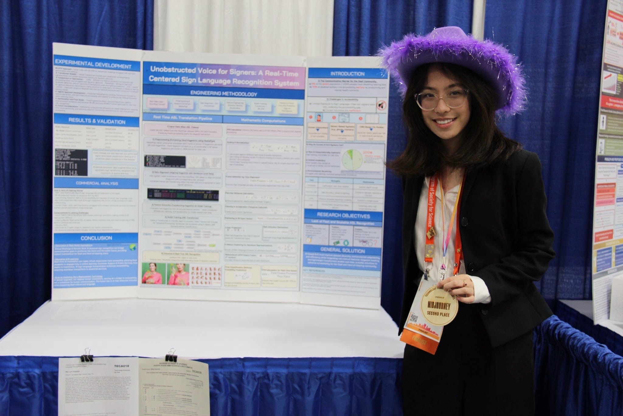 May wearing a purple hat and holding her ISEF award